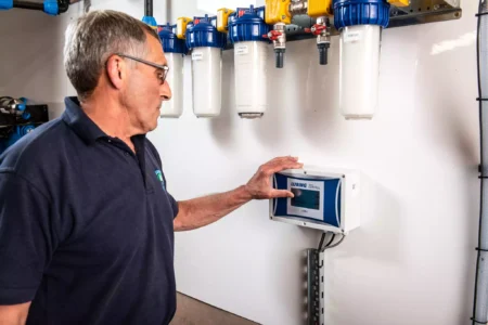 Technician operating a water filtration control panel